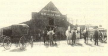 Stuart L. Dutton Livery Barn - 1914. L to R John Hall, S. L. Dutton, Thomas "Tall Tom" Boyer, boy with GRIT News Bag - Charlie Bowers