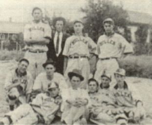 One of Mullen's early Baseball - Back Row L-R - Clyde Spear, Alex Burnett - manager, Elliott Lowe and Earl Borsteel Front - Warren Marcy, Roscoe Hill, Ernest Tschauder, Walter Scott, Lewis Lowe, Berlin Adams, Walter Kelly. Picture taken on Main Street Fred Cudabeck residence & Evergreen Hotel in early 1900's